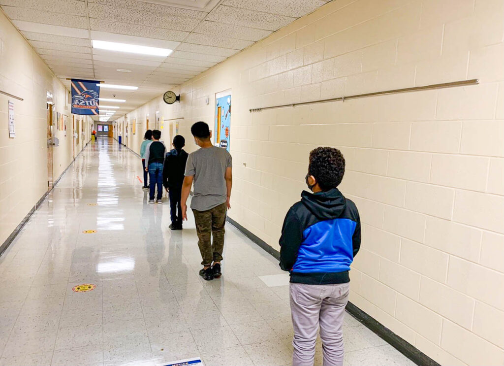 Mrs. Galvan’s students stand in a socially distant line to walk back to their classroom after a 15- minute break from technology. The school began “technology breaks” after the start of the pandemic in order to get students away from their laptop and encourage them to get some water, eat a snack, use the restroom, etc. before continuing another lesson on screen. Photo taken by Cristela Jones.